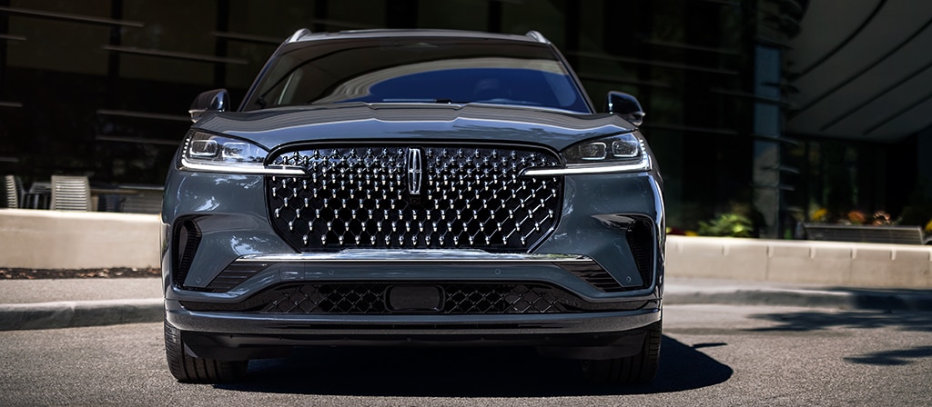 The dazzling grille of a 2026 Lincoln Black Label Aviator® SUV sparkles in the sunlight