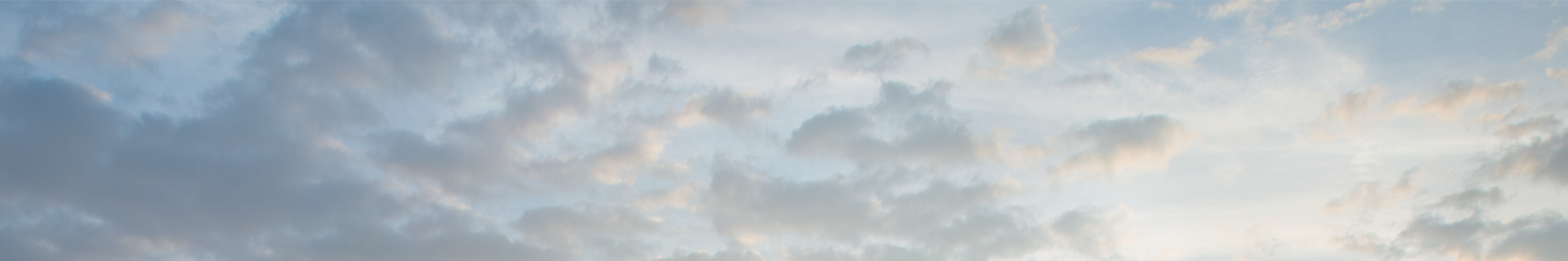 A background with a skyline and a sky with sun and clouds