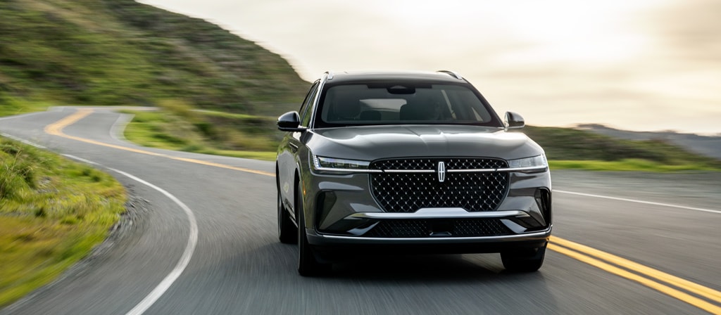 A 2026 Lincoln Black Label™ Nautilus® SUV is being driven on a waterfront roadway