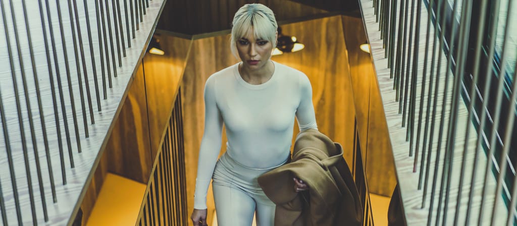 A woman ascends a stairway in a mountain chalet