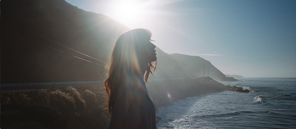 A woman enjoys a moment on a seaside overlook