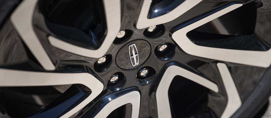 The available 24-inch High Gloss Ebony Black Wheel with Bright Machined Finish on a 2027 Lincoln Navigator® Black Label™ SUV