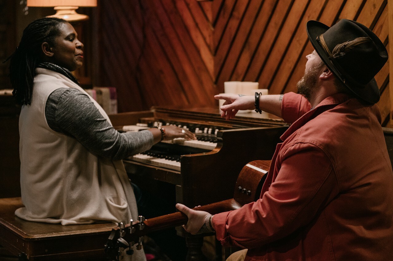 Cas Hanley cantando junto a una mujer que toca el piano.