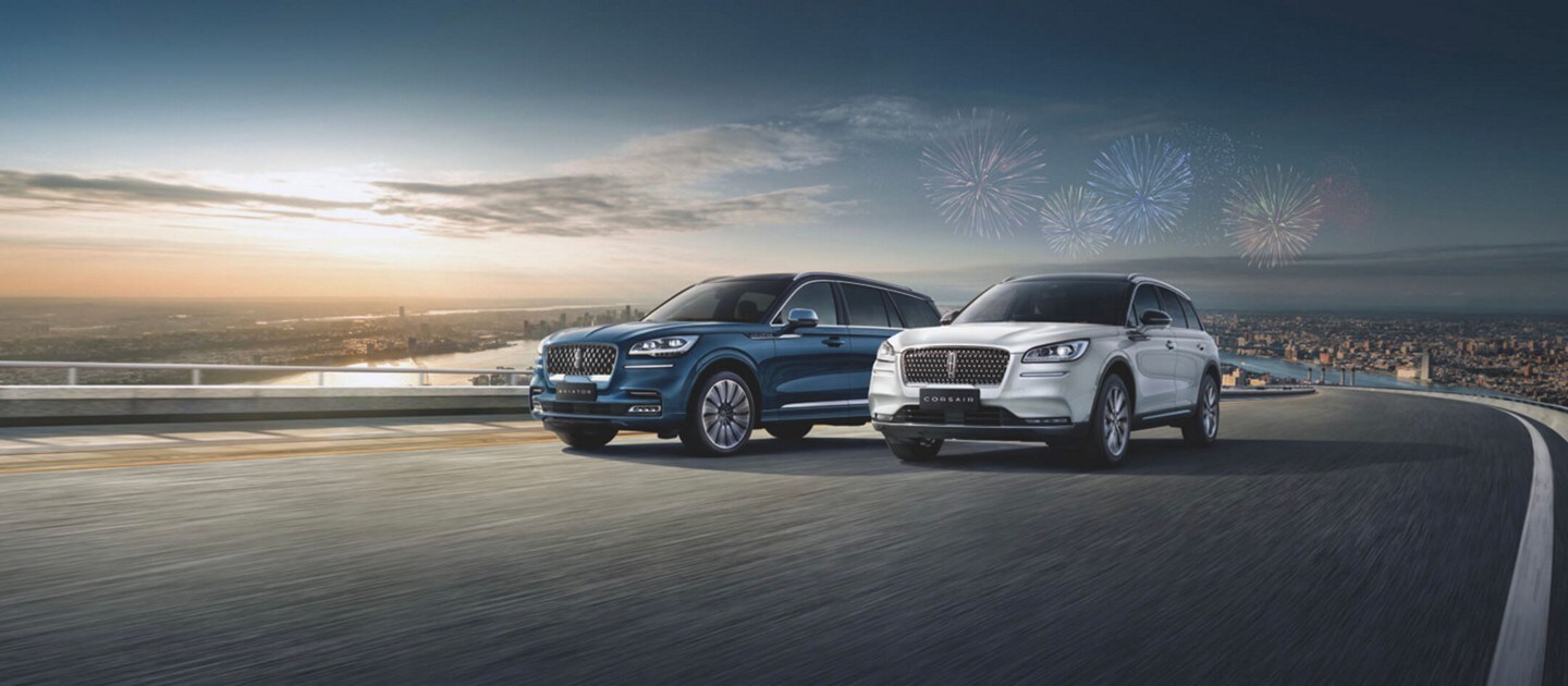 A Lincoln M K C in Blue Diamond and one in White Platinum are shown on a beach landscape