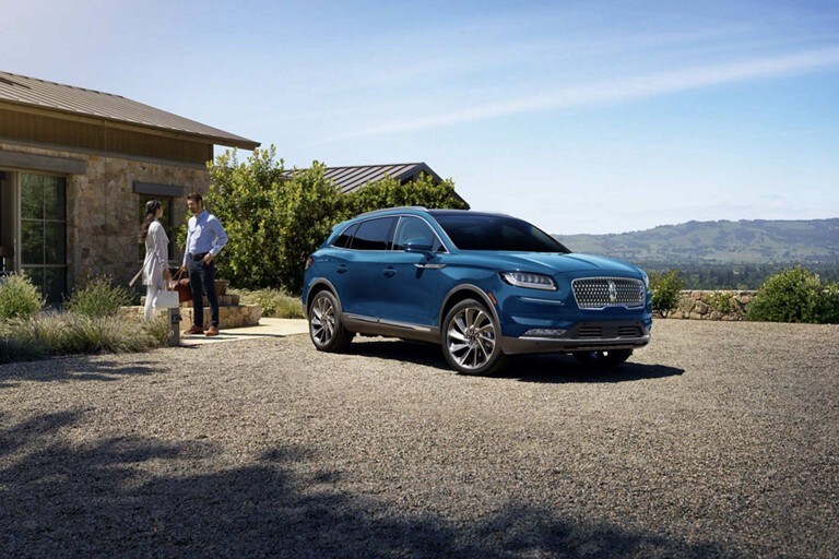 A 2018 Lincoln M K T in the Ingot Silver exterior color is being driven in the city