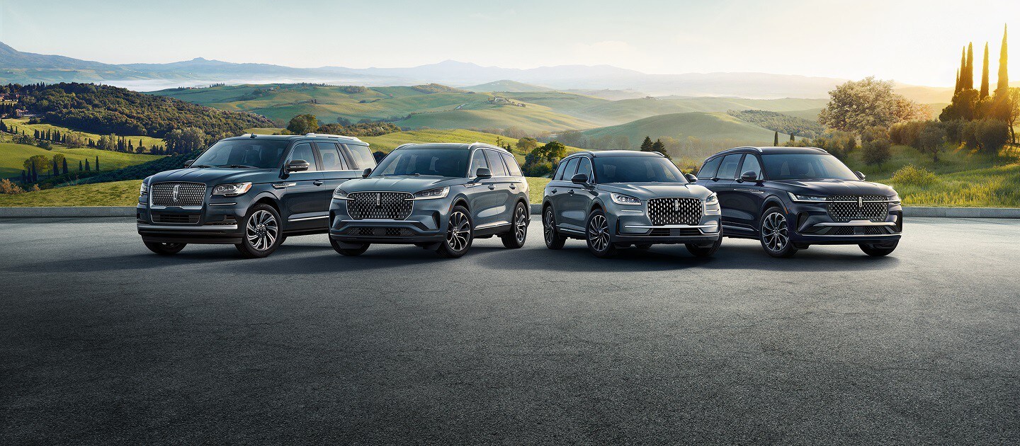 La línea de vehículos Lincoln estacionada frente a un campo abierto.