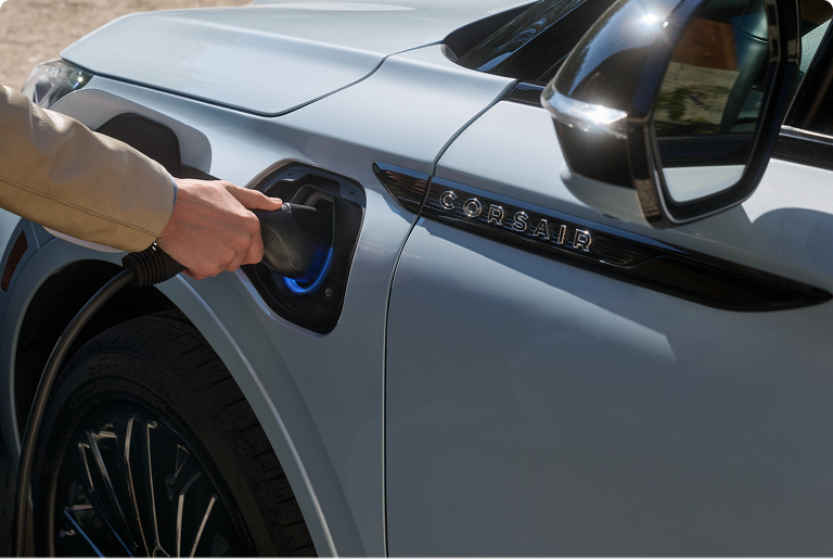 Una persona inserta el cable de alimentación Lincoln Mobile en el puerto de carga de un SUV Lincoln Corsair® Grand Touring Plug-In Hybrid