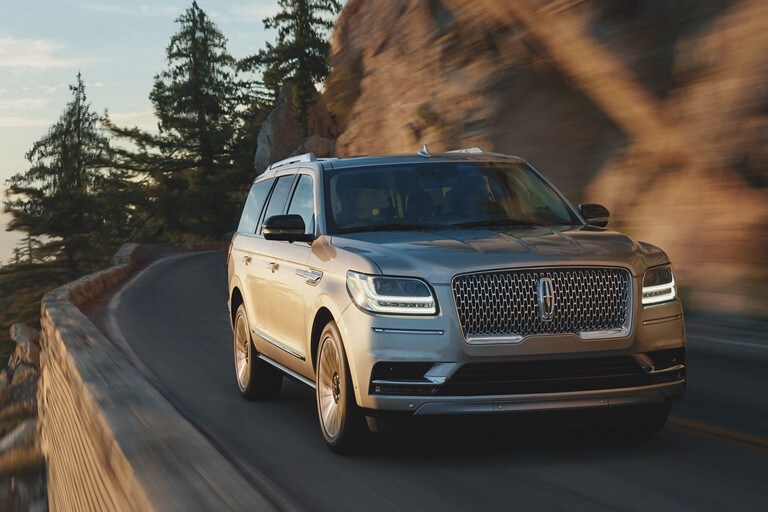 the 2021 LINCOLN NAVIGATOR is shown driving on a cliffside road