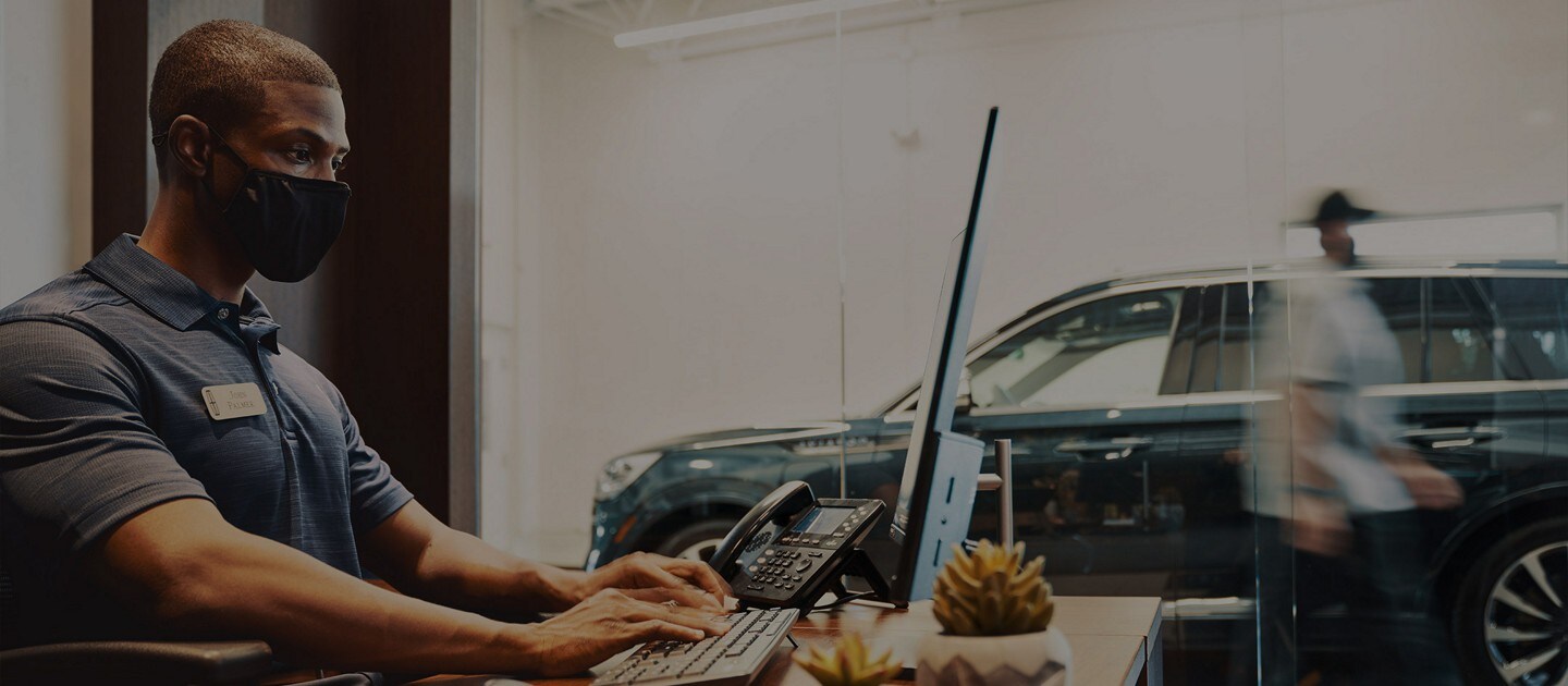 Customer service worker in front of computer at his desk.