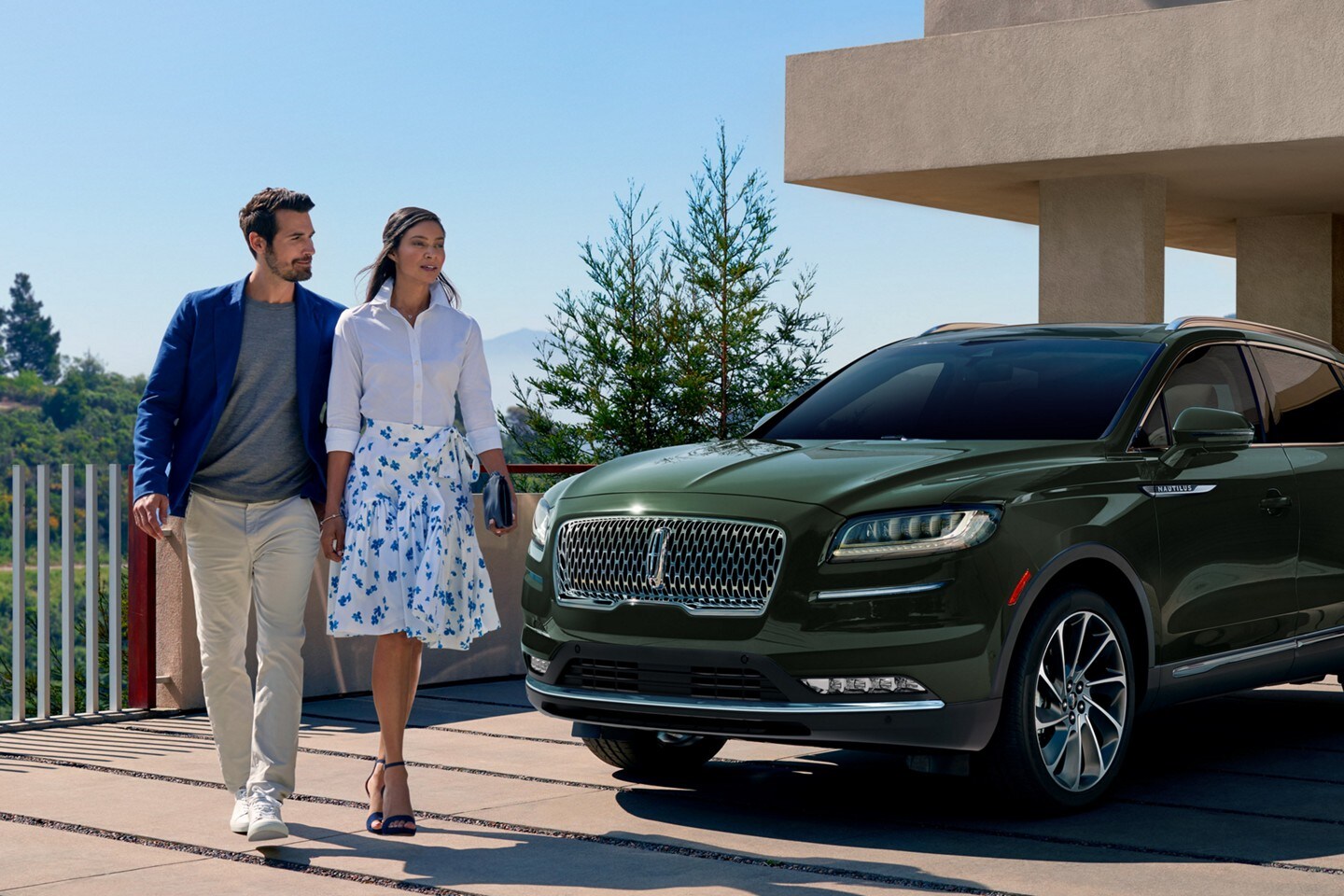 A couple standing by a Lincoln Nautilus Reserve model shown with available features.