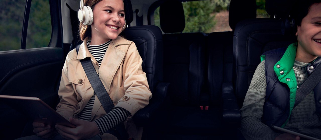 Two children are comfortably seated in the second row of a Lincoln Aviator®