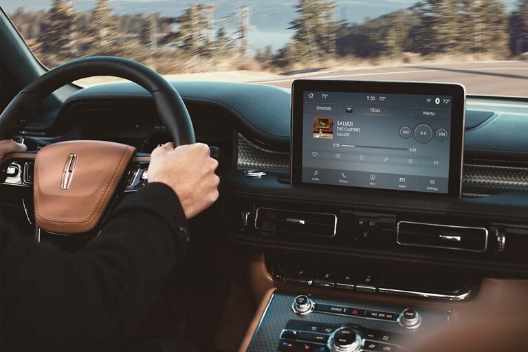 Una persona conduciendo una SUV Lincoln Aviator® 2023 por una carretera de montaña