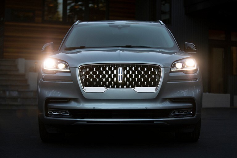 Se muestra un modelo Lincoln Aviator® Grand Touring 2023 con los faros delanteros encendidos