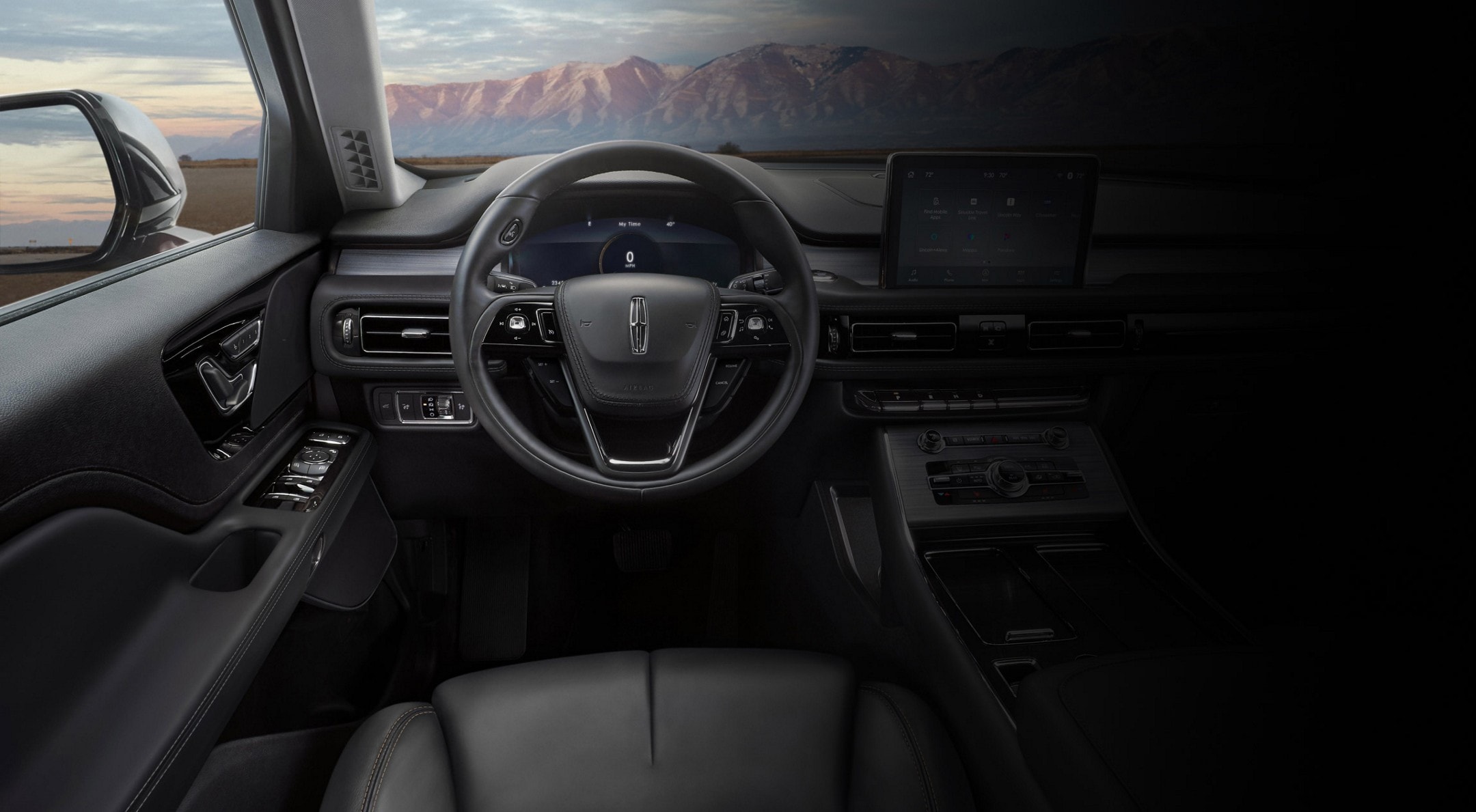 The front cabin of a 2024 Lincoln Aviator® is shown with a remote mountain range appearing through the windshield