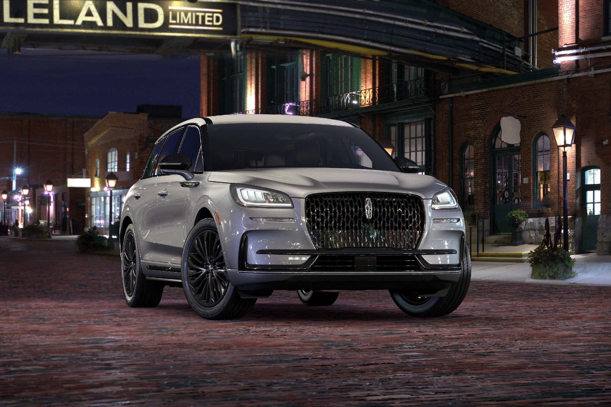 A silver Lincoln Corsair parked infront of a building.