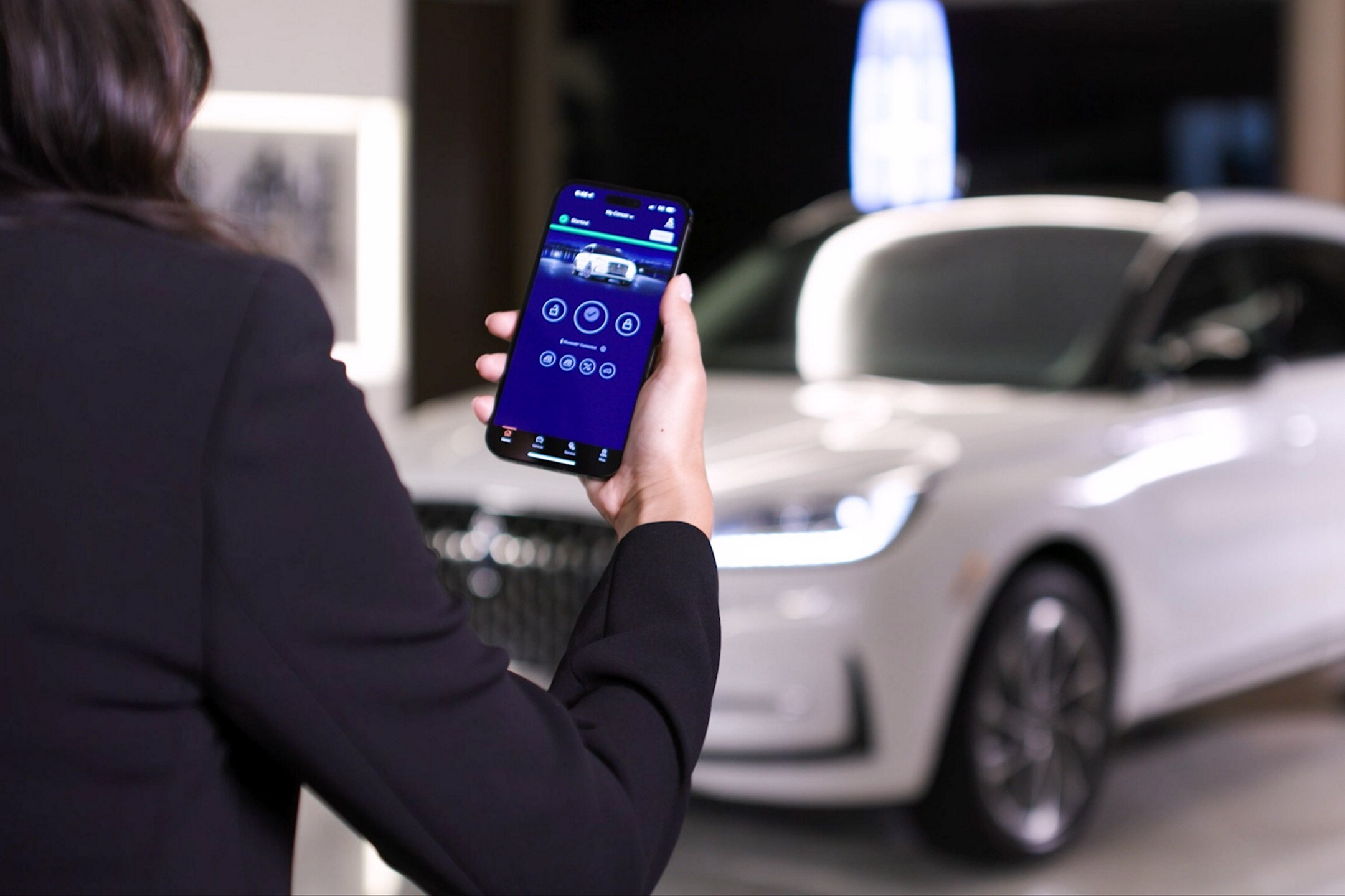 A woman using the Remote Keyless Entry System on her smart-phone.