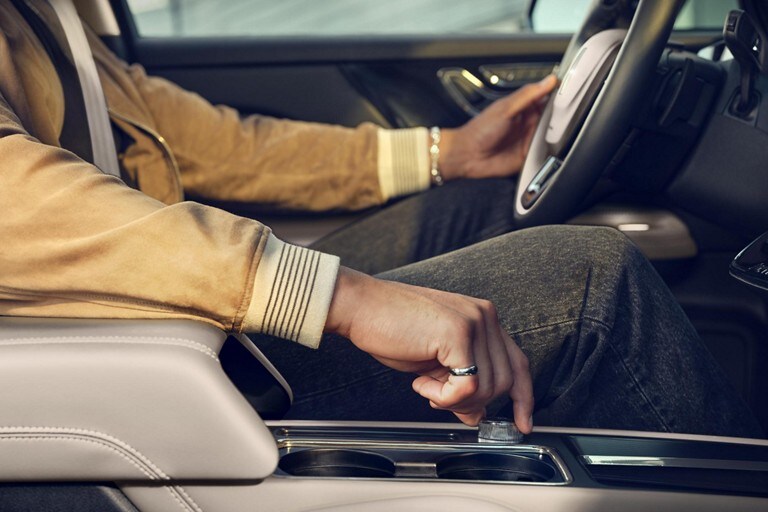 The hand of a person driving a 2024 Lincoln Corsair® SUV is shown adjusting the Drive Modes knob
