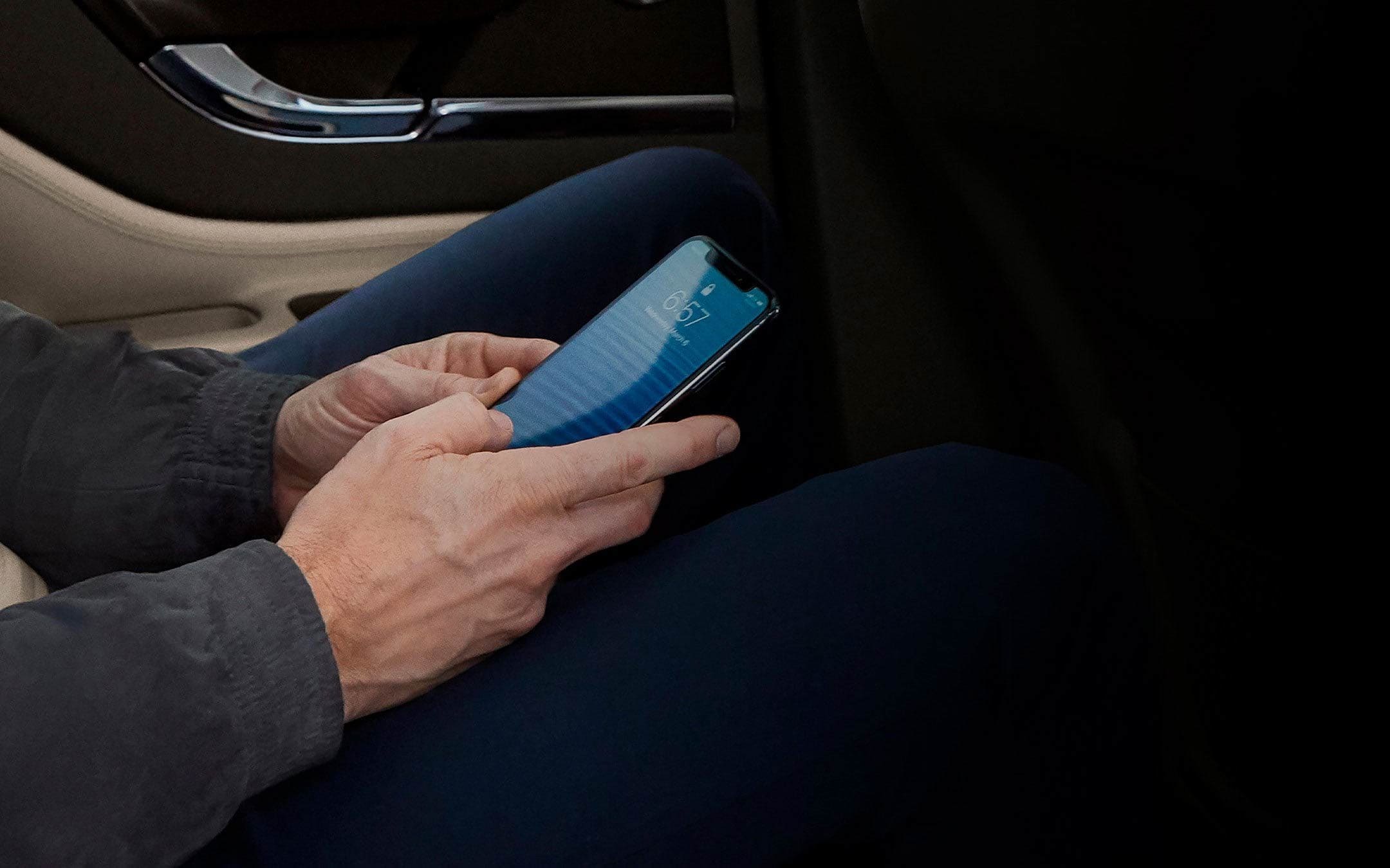 A person is shown using a mobile phone while using a 2025 Lincoln Corsair® SUV as a mobile Wi-Fi® hotspot