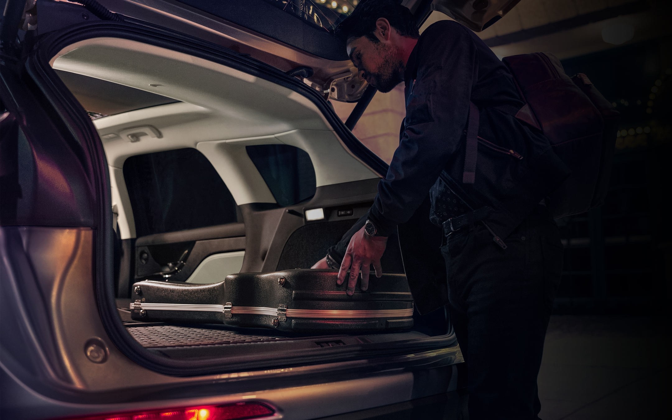 A musician loads musical equipment in the rear cargo area of a 2025 Lincoln Corsair® SUV