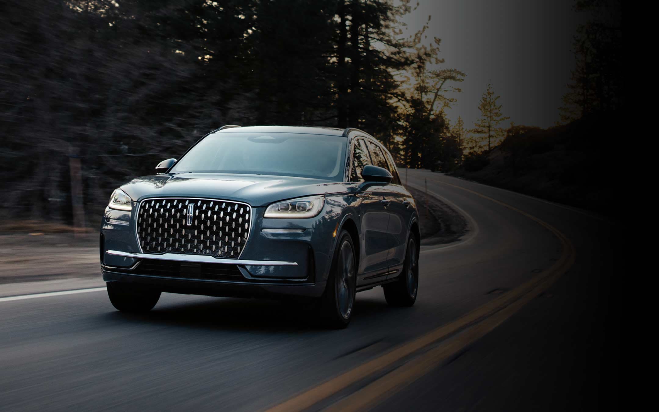 2026 Lincoln Corsair® Reserve model in the Whisper Blue exterior color is driven on a country road