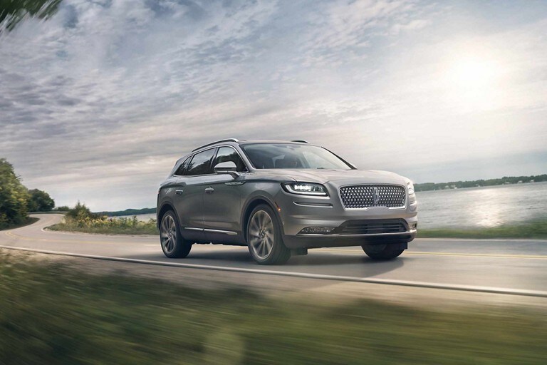 Una SUV Lincoln Nautilus® 2023 circulando por una carretera junto a un lago