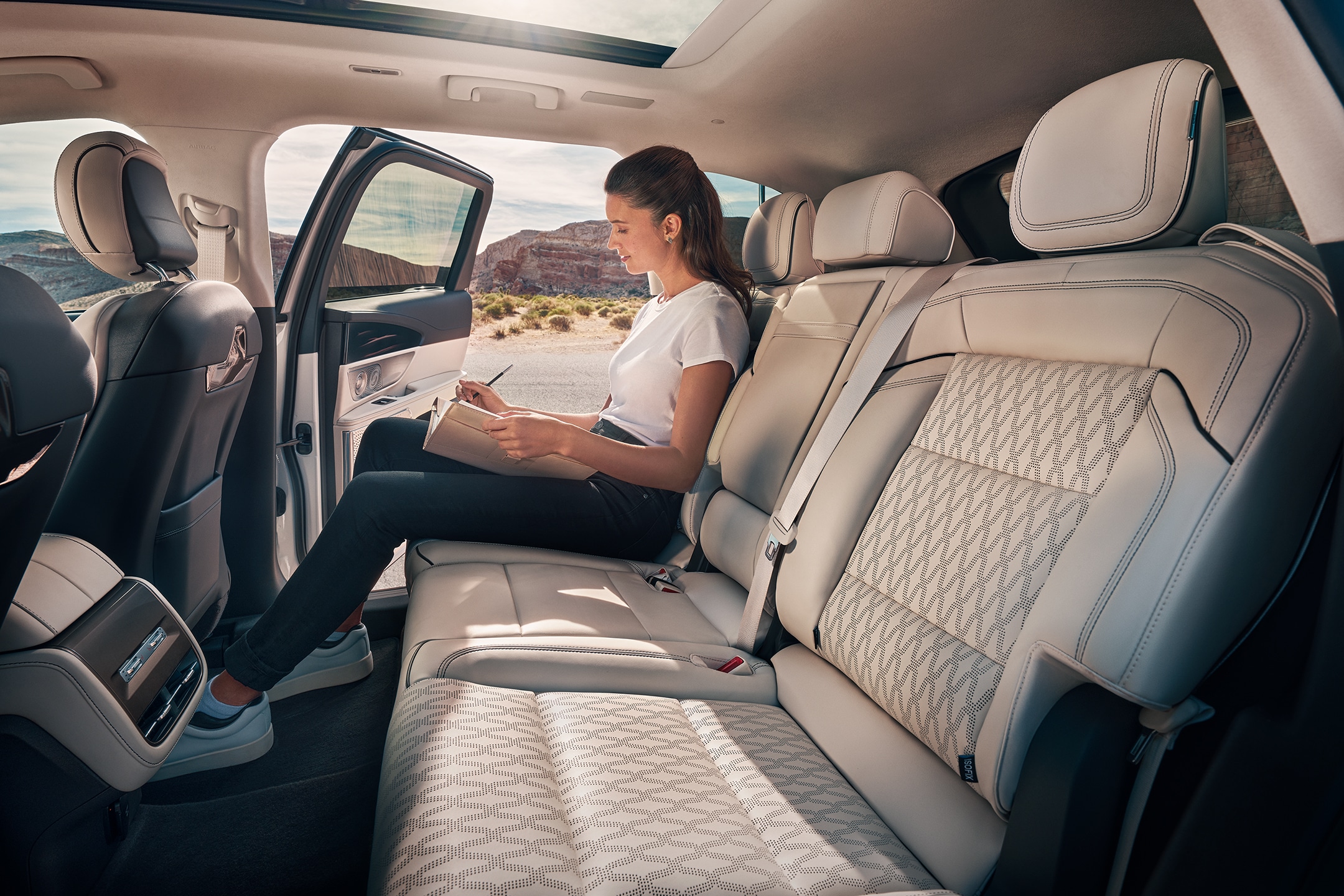 A person takes a relaxing moment in the second row of a 2024 Lincoln Black Label Nautilus® SUV.