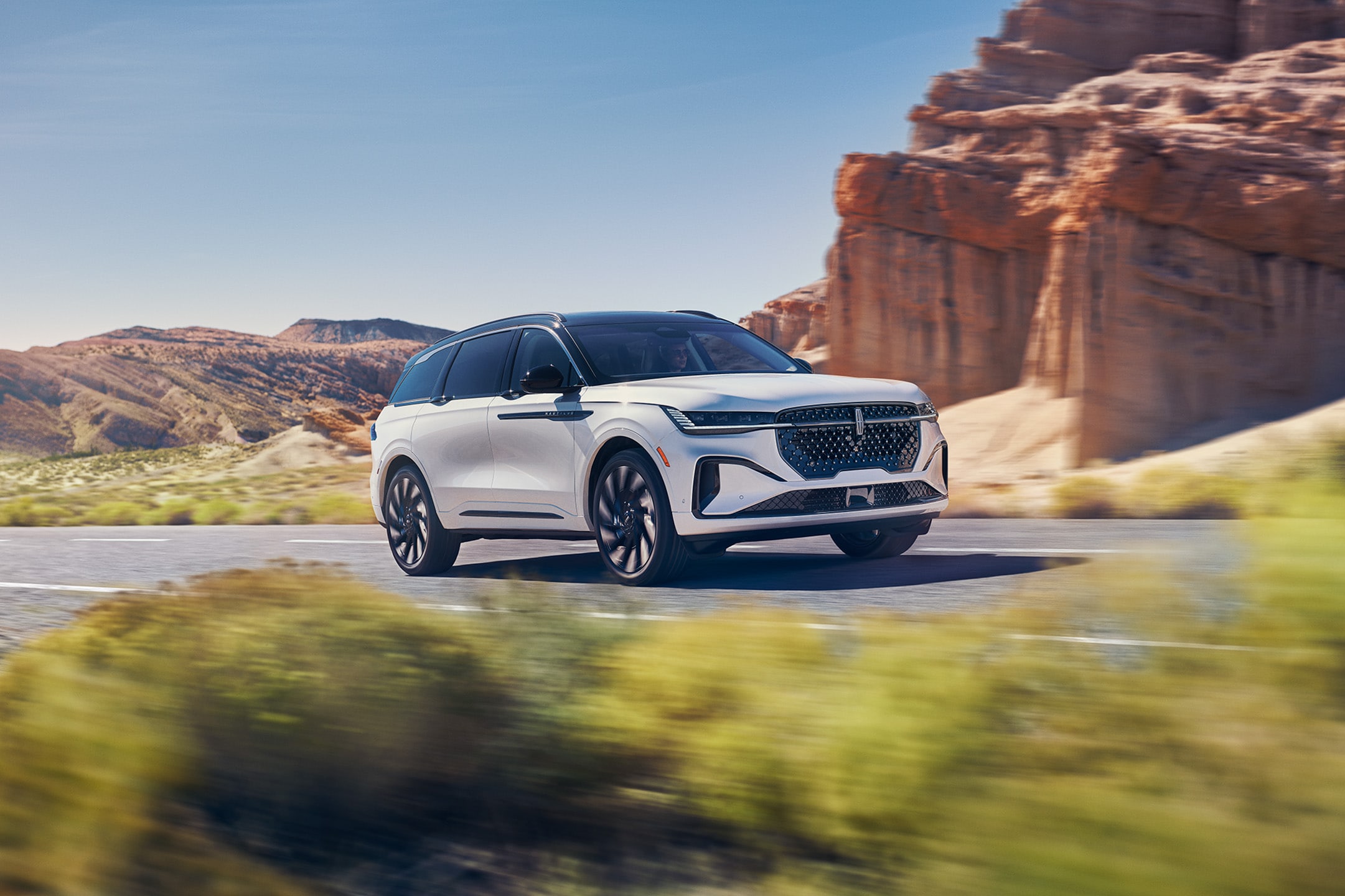 A 2024 Nautilus® Reserve model is being driven through a desert setting.