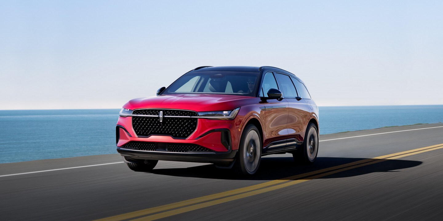 A 2024 Lincoln Nautilus SUV with the available Jet Appearance Package is being driven on an oceanside road