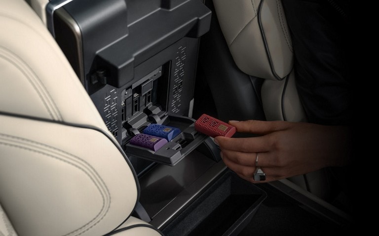 A hand inserts a Digital Scent cartridge in the opened storage bin of a 2026 Lincoln Nautilus® SUV