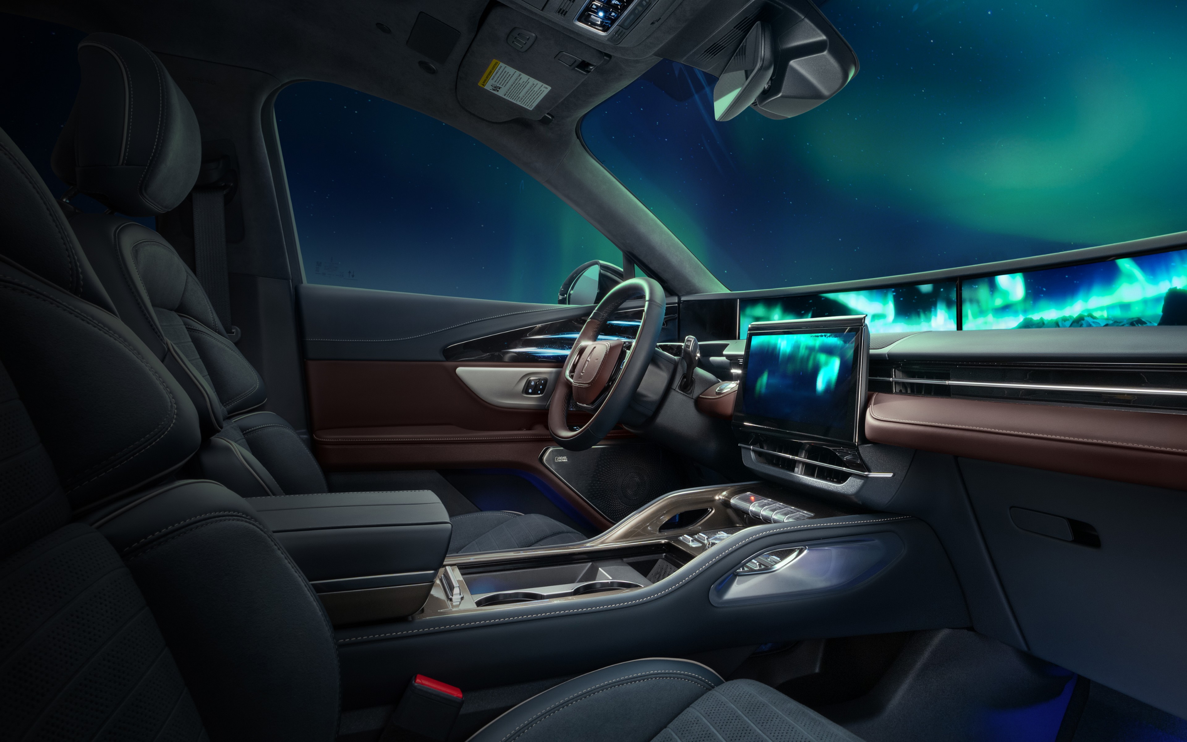 The northern light light up the night sky as seen through the windshield of a 2026 Lincoln Black Label™ Nautilus® SUV with the Aurora interior theme
