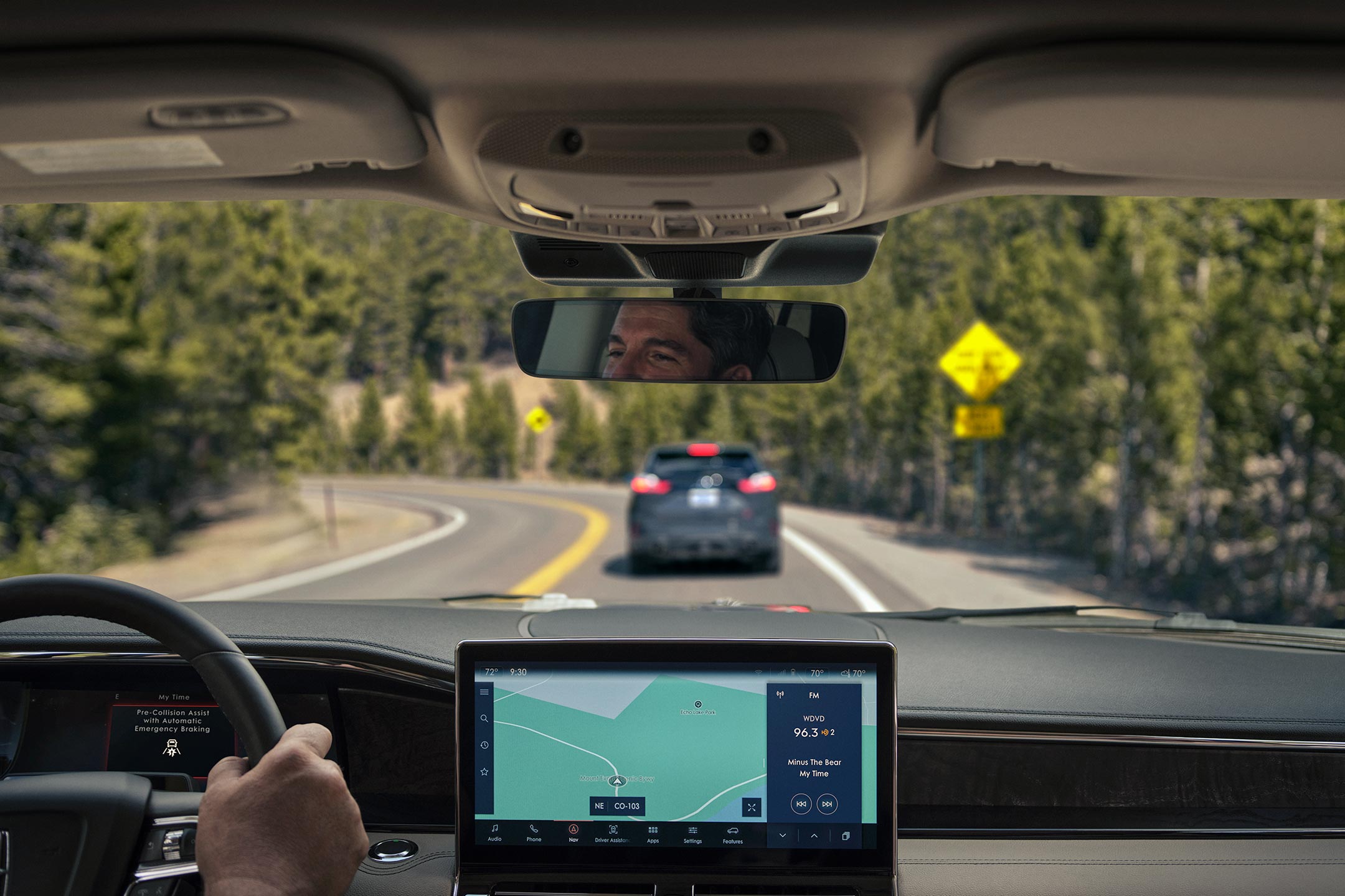 A través del parabrisas de una SUV Lincoln Navigator® 2024 podemos ver un auto delante que frena.
