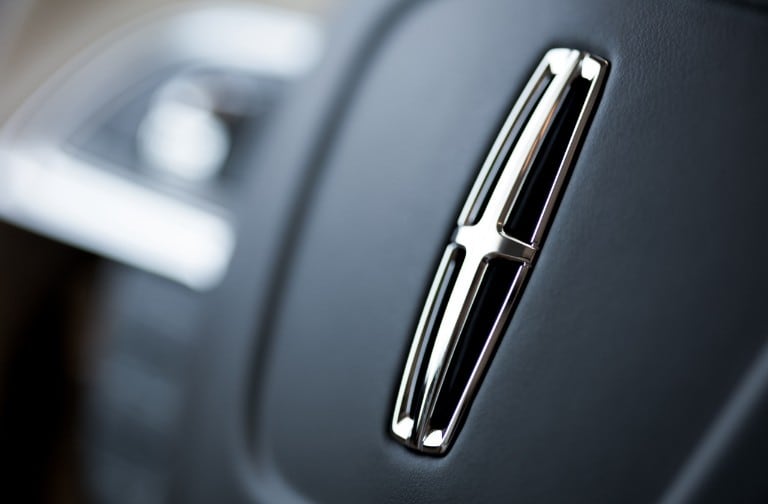 Close up shot of the Lincoln emblem on the center of the steering wheel
