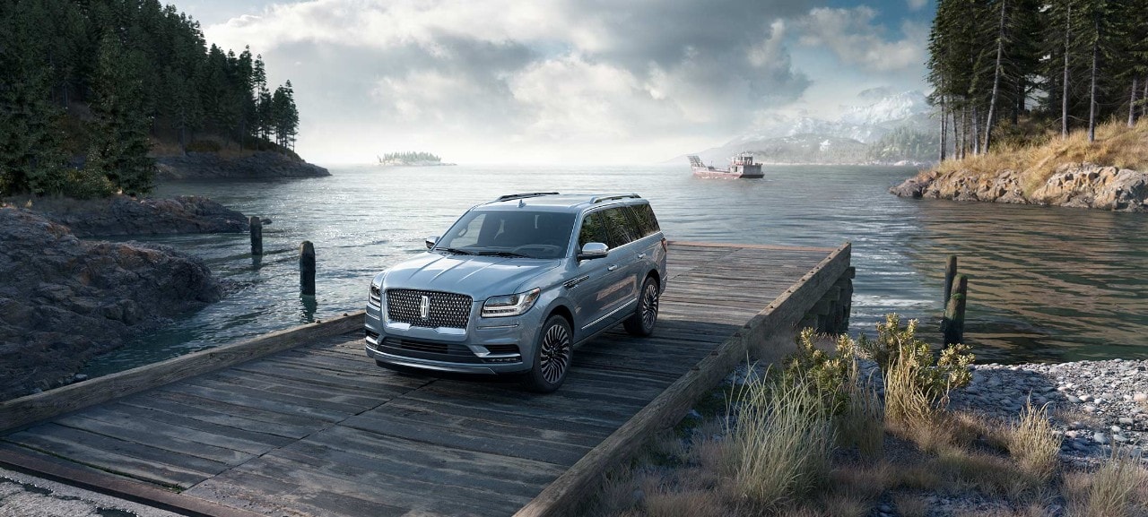 Black Label Lincoln Navigator on a pier with mountains in the background