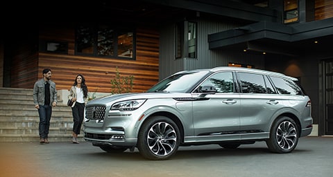 Una pareja se acerca a su nueva Lincoln Aviator