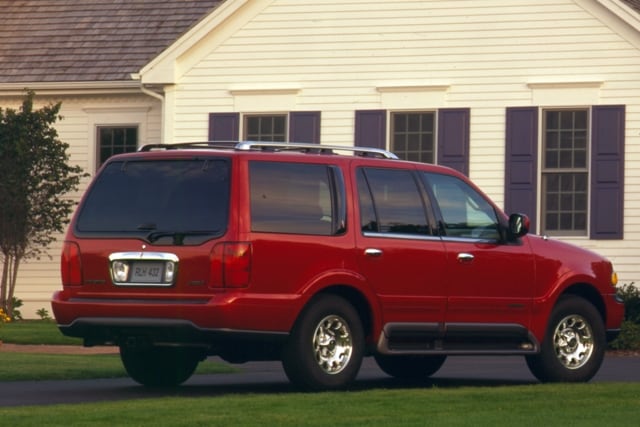 A red 1998 Lincoln Navigator is shown here in front of a house