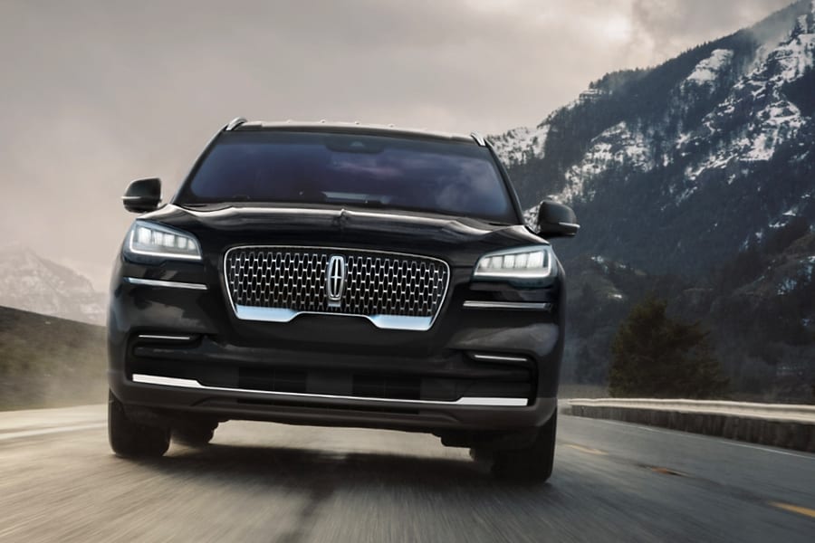 Se muestra un modelo Lincoln Aviator Grand Touring 2022 andando por un camino de montaña.