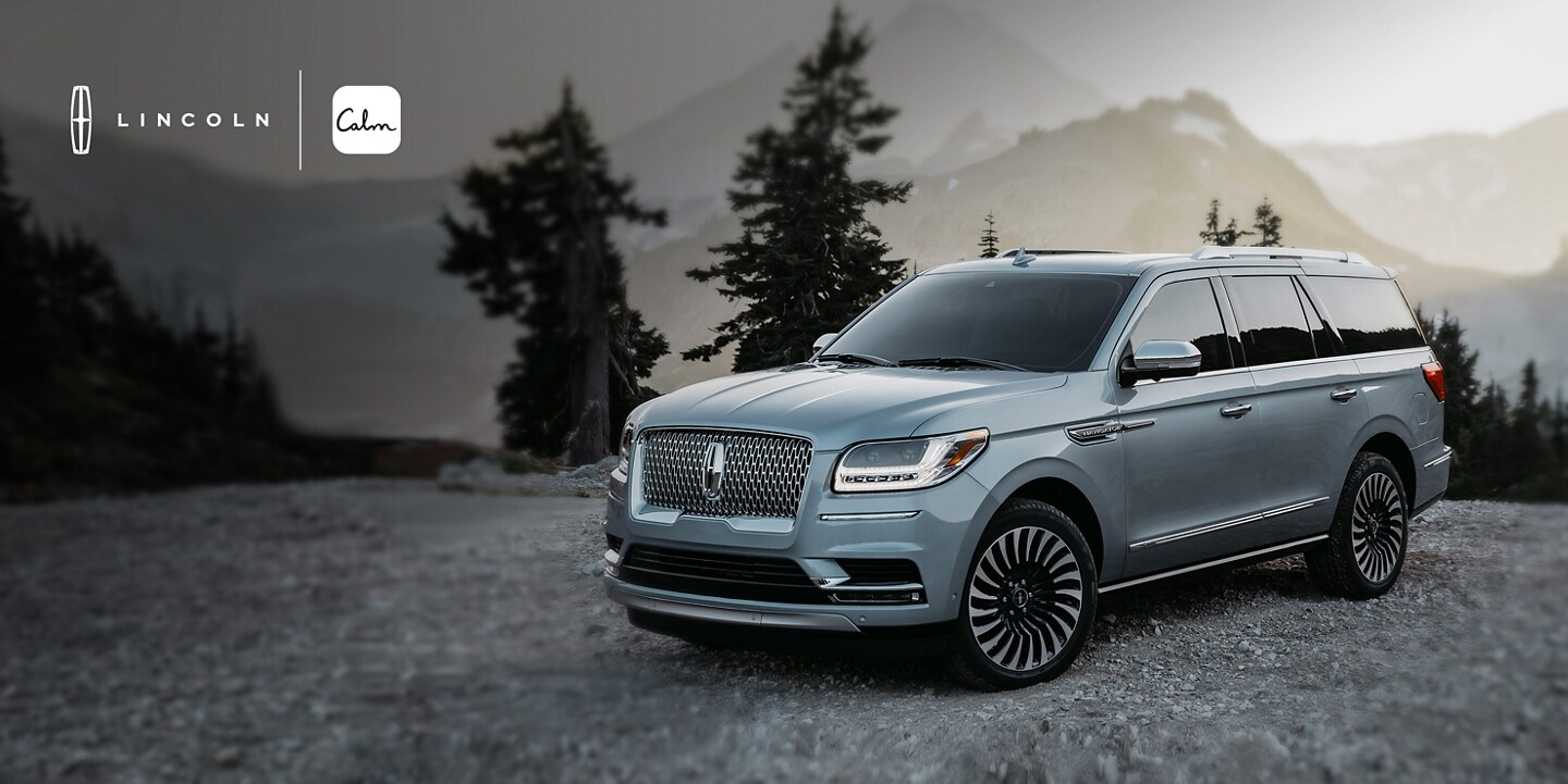 Lincoln. Calm. A Lincoln luxury SUV at a scenic mountain overlook is shown here