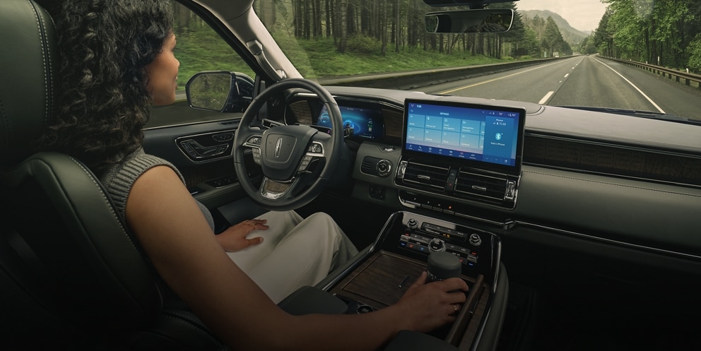 El conductor de una SUV Lincoln Black Label Navigator® 2023 se relaja con la tecnología de manejo manos libres activada.