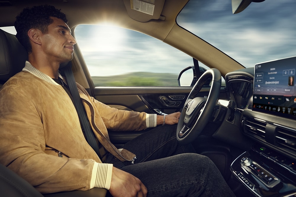 A man drives a 2023 Lincoln Corsair® with his hands off the wheel and eyes on the road.