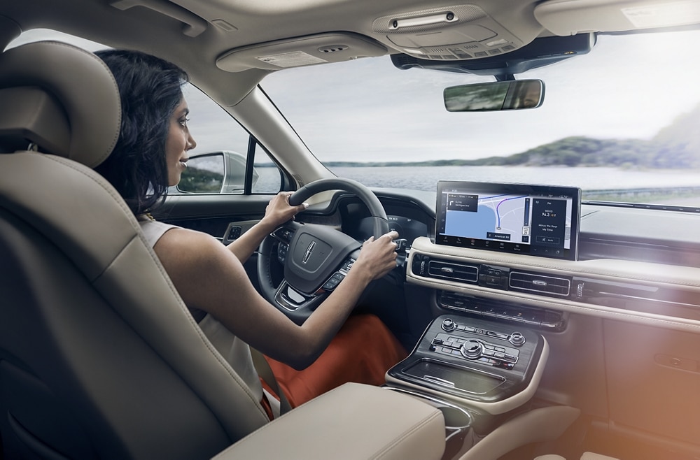 A woman a 2023 Lincoln Nautilus® while looking at a map on the center display.