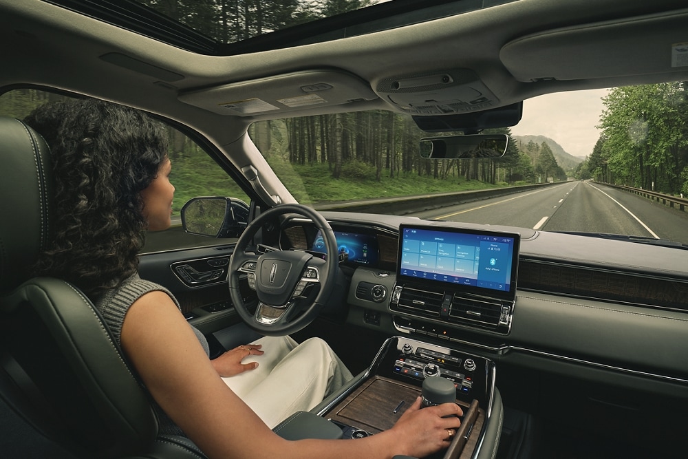 Una mujer conduce una Lincoln Navigator® 2023 con manos libres con la vista en la carretera.