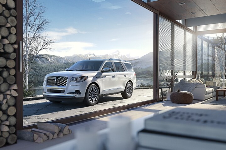 Una SUV Lincoln Black Label Navigator® 2024 en Chalet estacionada cerca de una montaña nevada.