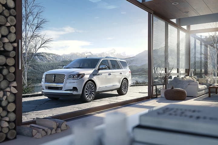 A 2024 Lincoln Black Label Navigator® SUV in Chalet is parked near a snowy mountain.