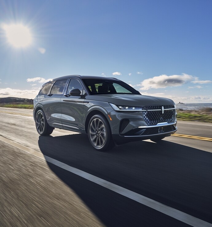 A 2025 Lincoln Black Label Nautilus® SUV is being driven on a country road