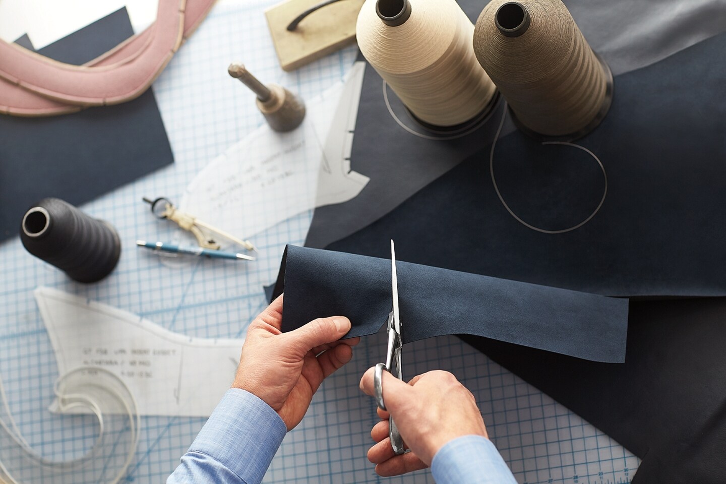 A man cutting a piece of fabric.