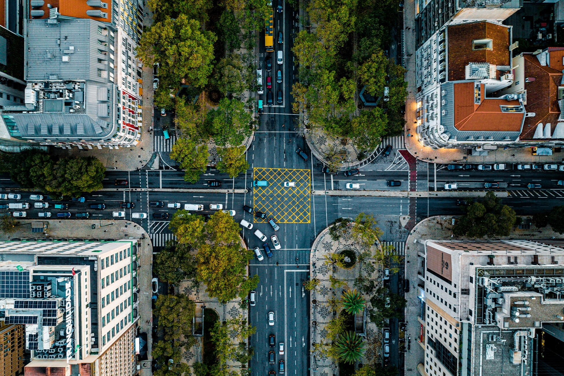 A busy city street with many cars travelling on the road.