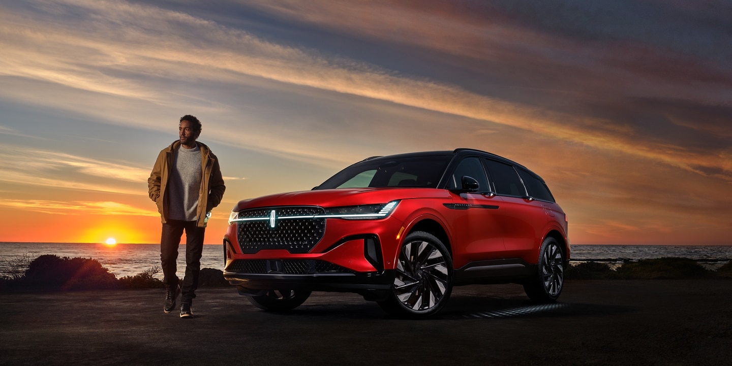A 2024 Lincoln Nautilus SUV with the available Jet Appearance Package is being driven on an oceanside road
