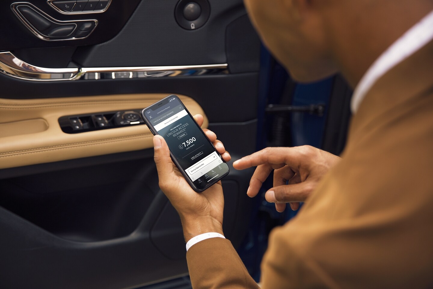 A Lincoln customer checking his Licnoln Access Reward Points on his phone.