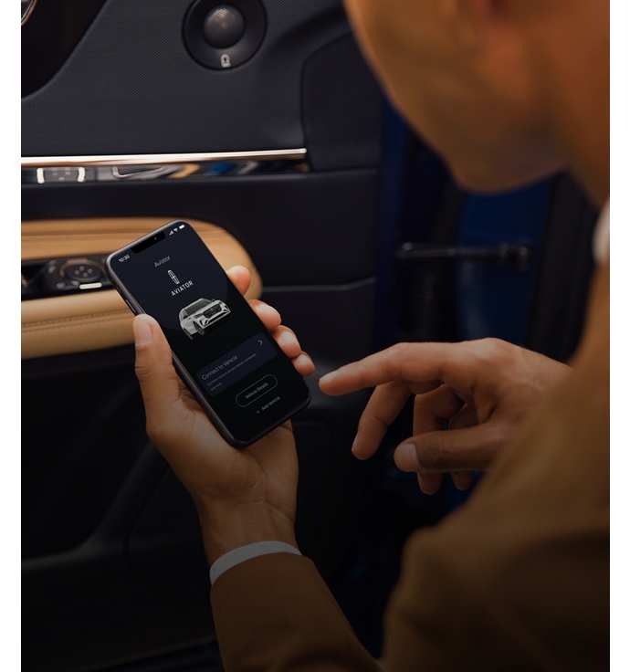 A man holding a phone viewing the Lincoln Rewards App.