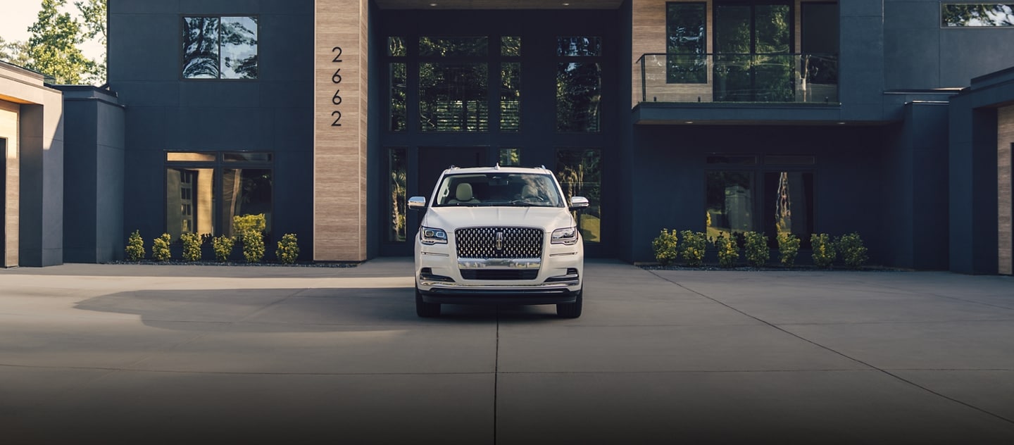 The Lincoln Navigator parked outside a house.